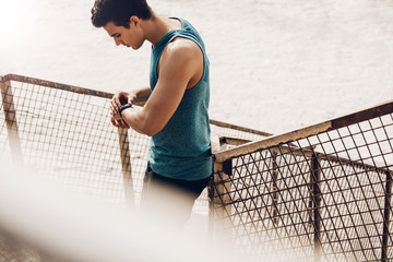 Male runner checking progress on smart watch