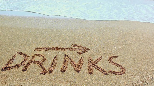 Inscription Drinks and the arrow drawn on the beach sand with a soft transparent.