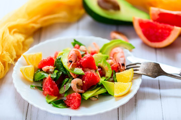 Salad with shrimps, avocado and grapefruit on a light background
