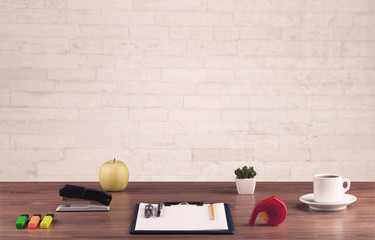 Office desk closeup with white brick wall