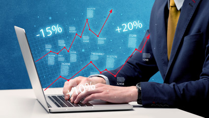 Salesman working on graph with laptop