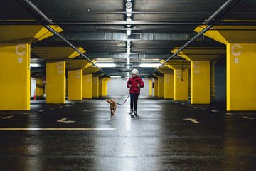 Girl with a dog walking the public garage
