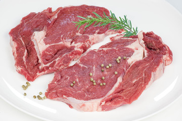 deux entrecôtes de boeuf  crues sur fond blanc