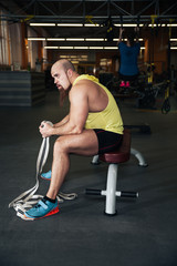 Man rests in gym after having a workout