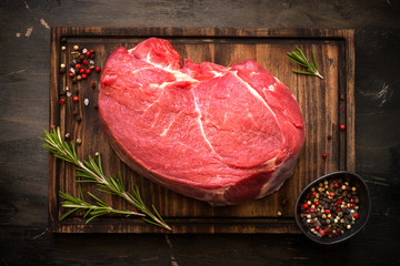 A large piece of beef chop on a cutting board. raw meat.