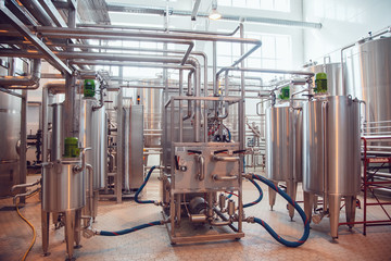 Modern beer plant, with brewing kettles, vessels, tubs and pipes made of stainless steel. Brewery.