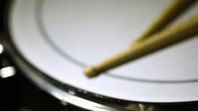 Shot of a snare drum and a pair of drumsticks, with focus transition.