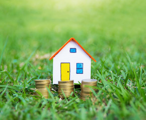 House model and coin money on gras.