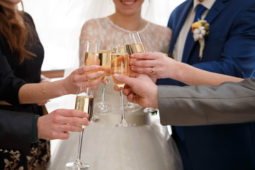 young and beautiful bride and groom clink glasses with the guest