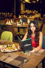 Young woman reading restaurant menu