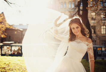 Fototapeta premium Happy beautiful bride posing in the old city