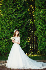 Obraz na płótnie Canvas Portrait of beautiful happy bride in luxury weding gown