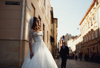 Obraz premium Happy beautiful newlyweds posing in the old city