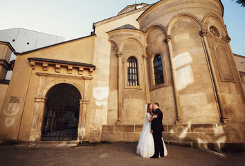 Happy beautiful newlyweds posing in the old city