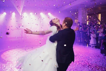 Happy beautiful newlyweds dancing in the restaurant