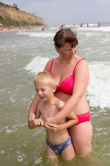 Naklejka premium mother hugging son at sea