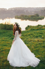 Fototapeta na wymiar Portrait of the bride in the wreath next to the lake