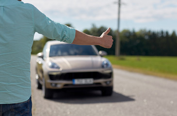 man hitchhiking and stopping car with thumbs up