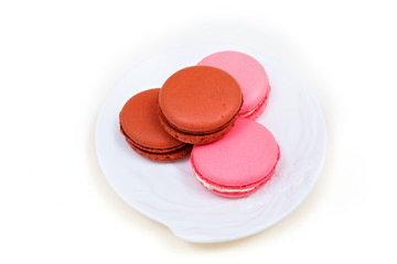 Macarons on the saucer on the white background.