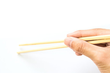 hand holding wooden chopstick on white background