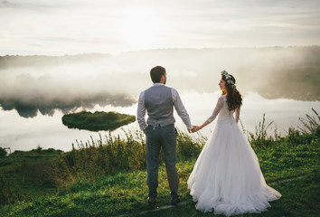 Newlyweds are holding hands of each other