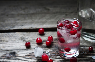 Bottle and Shot of Vodka with Raspberry on old wooden background