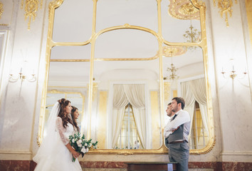 Golden mirror and newlyweds next to it