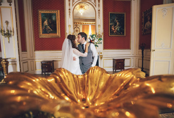 Kiss of the newlyweds in the luxury red room
