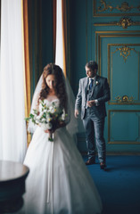 Bride in the blue room and a groom behind
