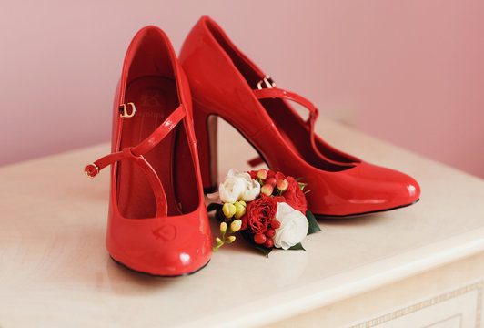 Red bridal shoes and wedding boutonniere