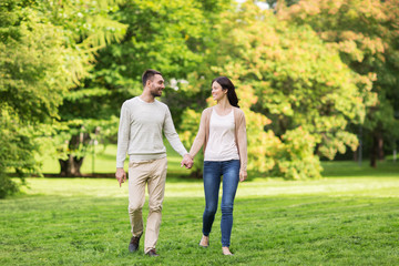 happy couple walking in summer park