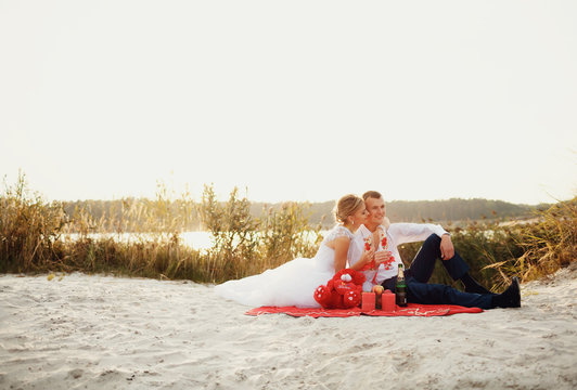 Romantic picnic of the newlyweds in the sandy beach