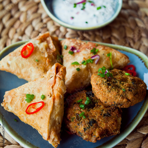 "Indian Vegetable snacks pakora, samosa, onion bhaji with coriander