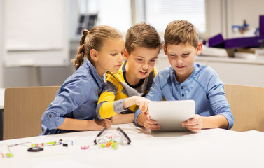 kids with tablet pc programming at robotics school