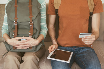Young couple going on a trip. Ordering tickets online with credit card and digital tablet. Active lifestyle and travel vacation concept