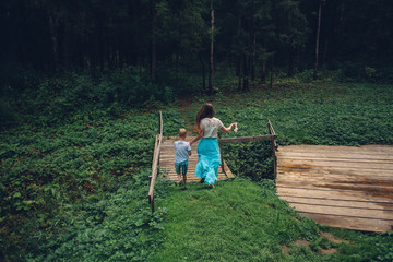 mother and son flee across the river in the forest