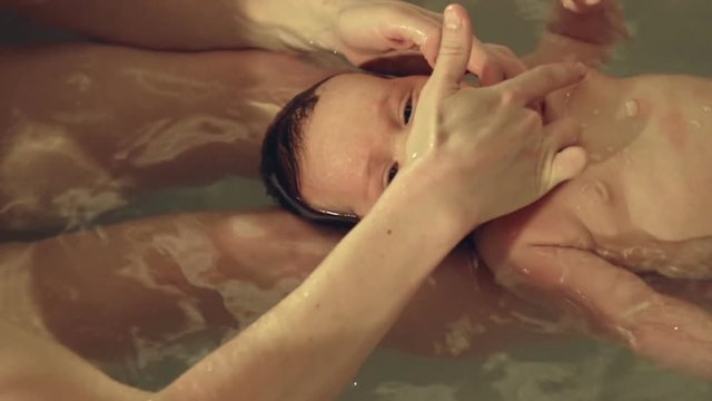 Cute little baby in the bathtub with his mother
