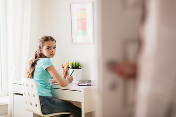 girl with laptop writing to notebook at home