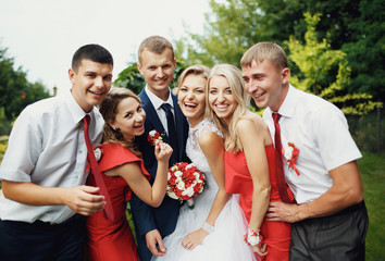Funny newlyweds with the friends in the park