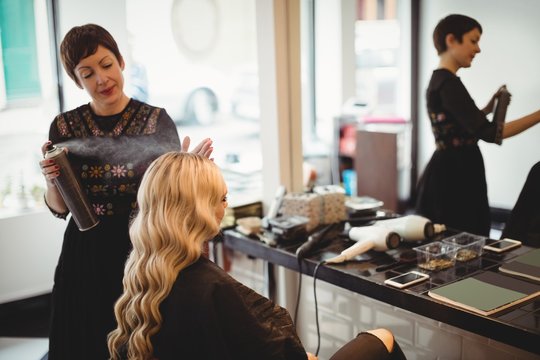 Female hairdresser styling clients hair