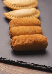 Several croquettes and small feet on slate plate. Vertical shoot..