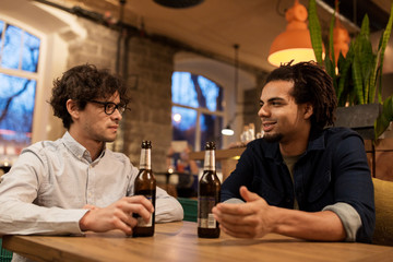 happy male friends drinking beer at bar or pub
