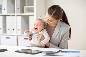 happy businesswoman with baby working at office