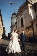 happy young boy holding the hand of his beautiful bride