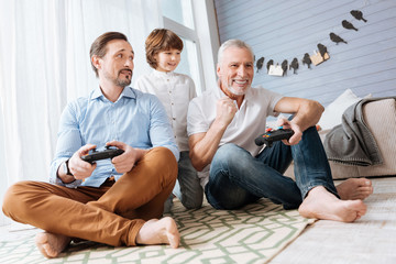 Delighted handsome men sitting cross legged