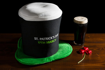 St Patrick day with a pint of black beer, hat and shamrock - Powered by Adobe