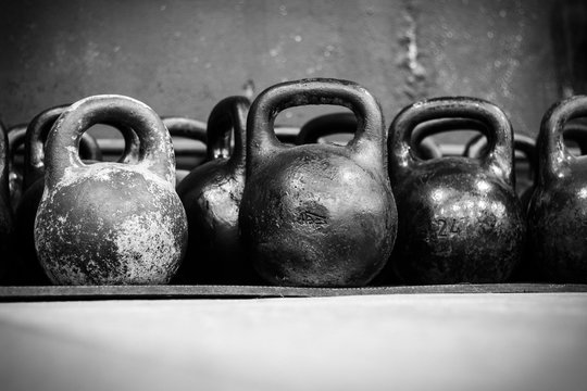 Old worn dumbells in gym in black and white