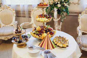 beautiful buffet table with fruit and cakes