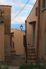 Narrow pedestrian street. You can see Tyrrhenian Sea in the background. Tindari. Sicily