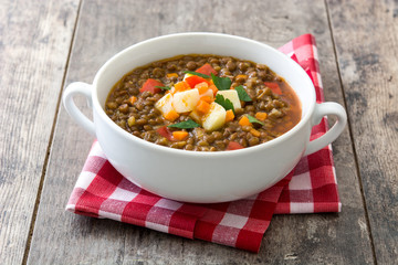 Lentil soup in a bowl on wooden background
